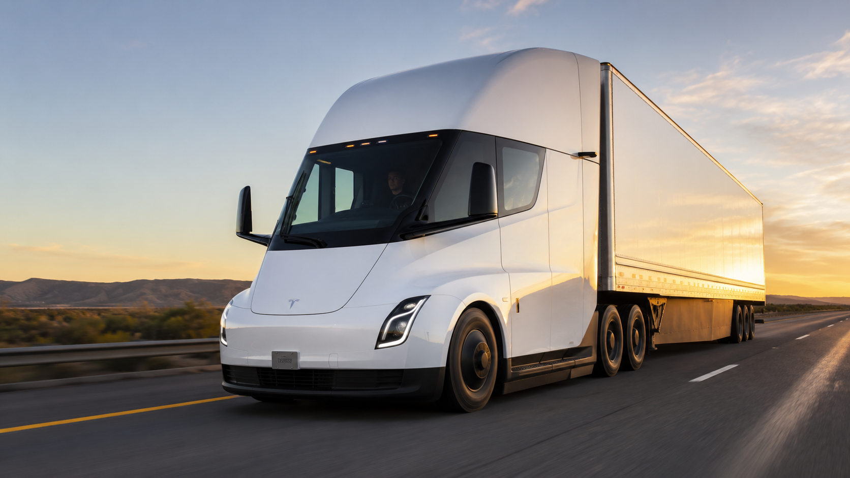Tesla Semi electric Class 8 long-haul truck driving on a California highway at golden hour with mountains in the distance